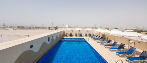 Piscine extérieure, parasols de plage, chaises longues