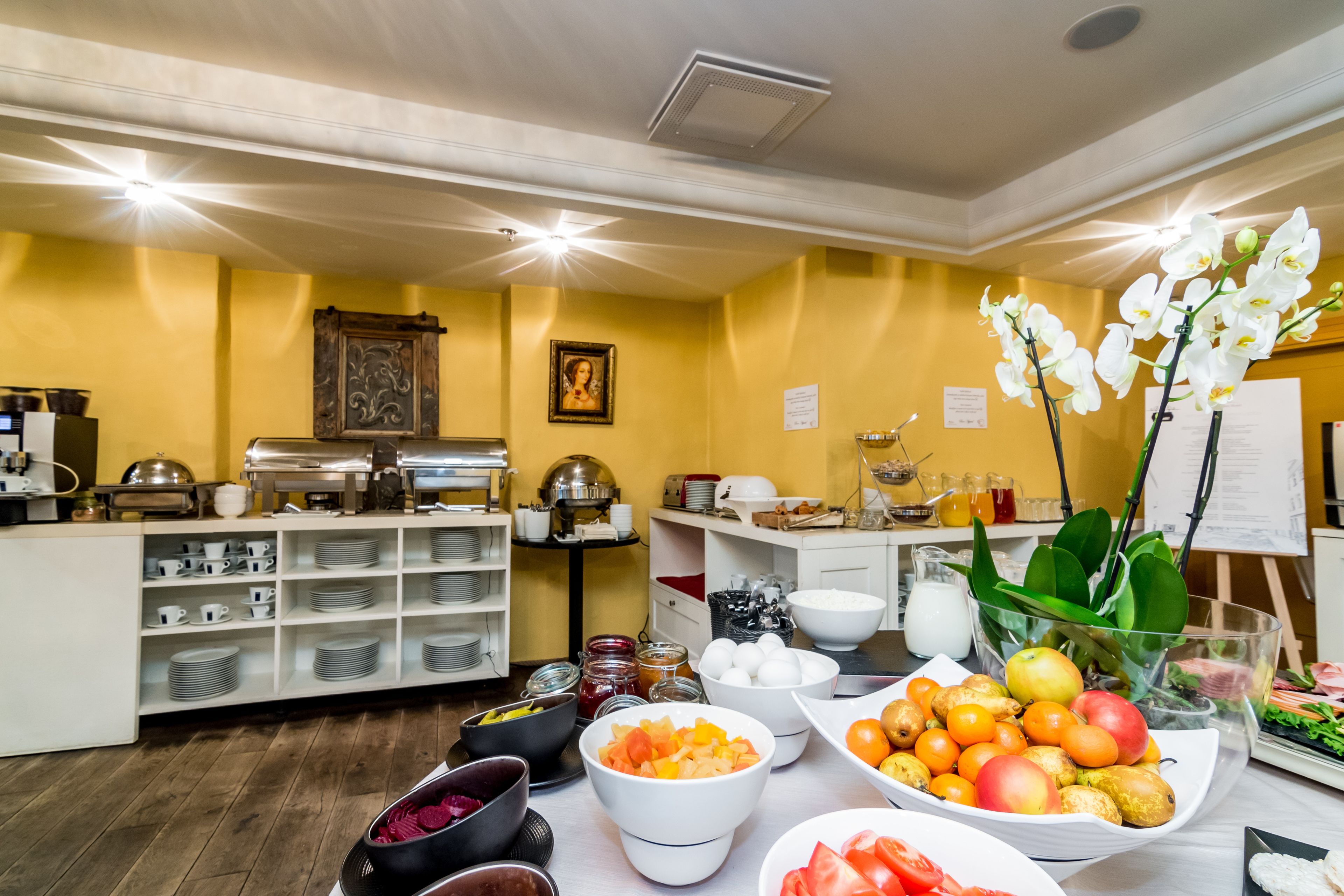 Een buffetopstelling met diverse gerechten en een decoratieve orchidee.