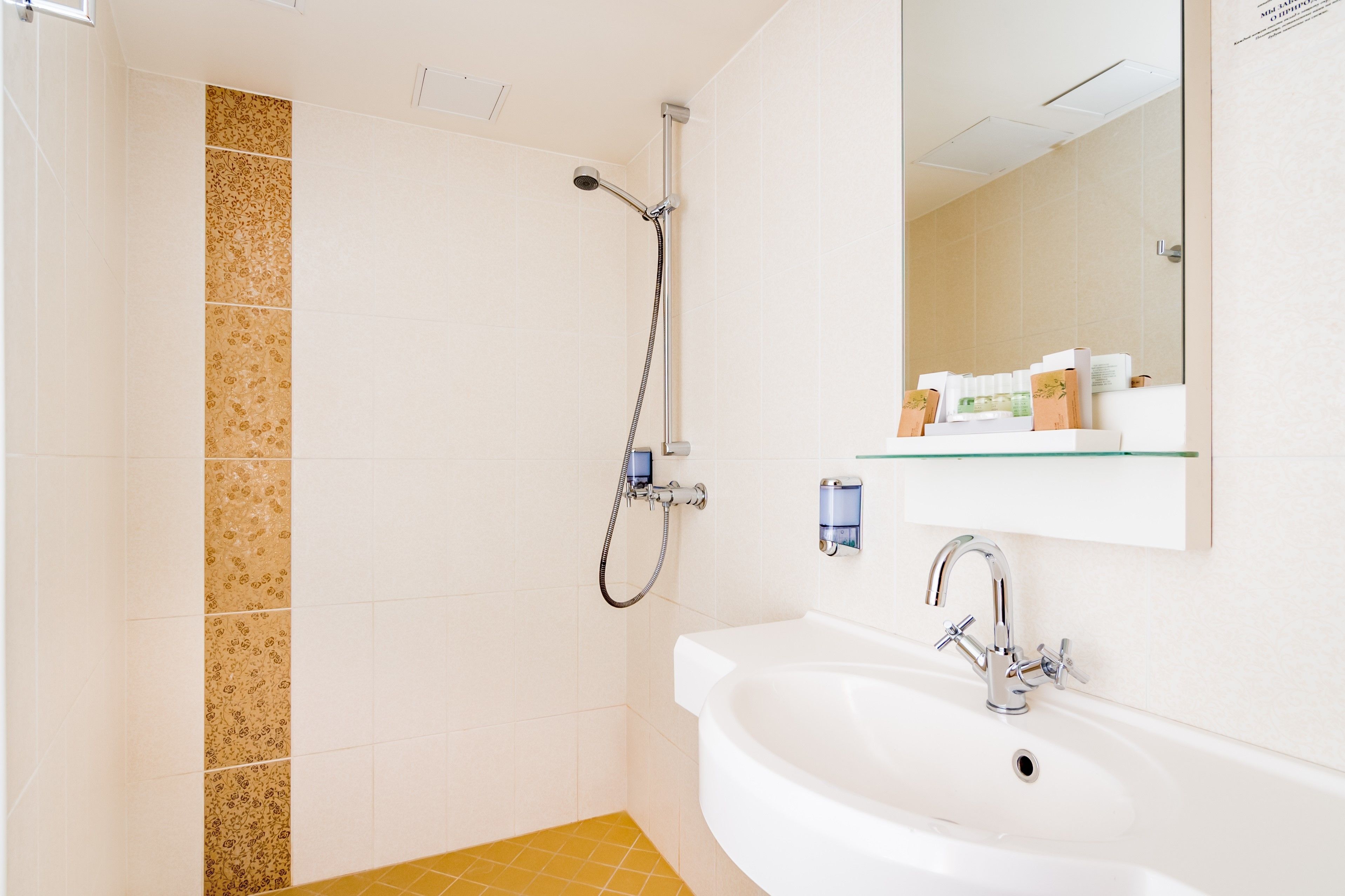 Un baño con ducha, lavabo y espejo.