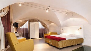 Une chambre à coucher avec un lit, un fauteuil jaune et une table en verre.