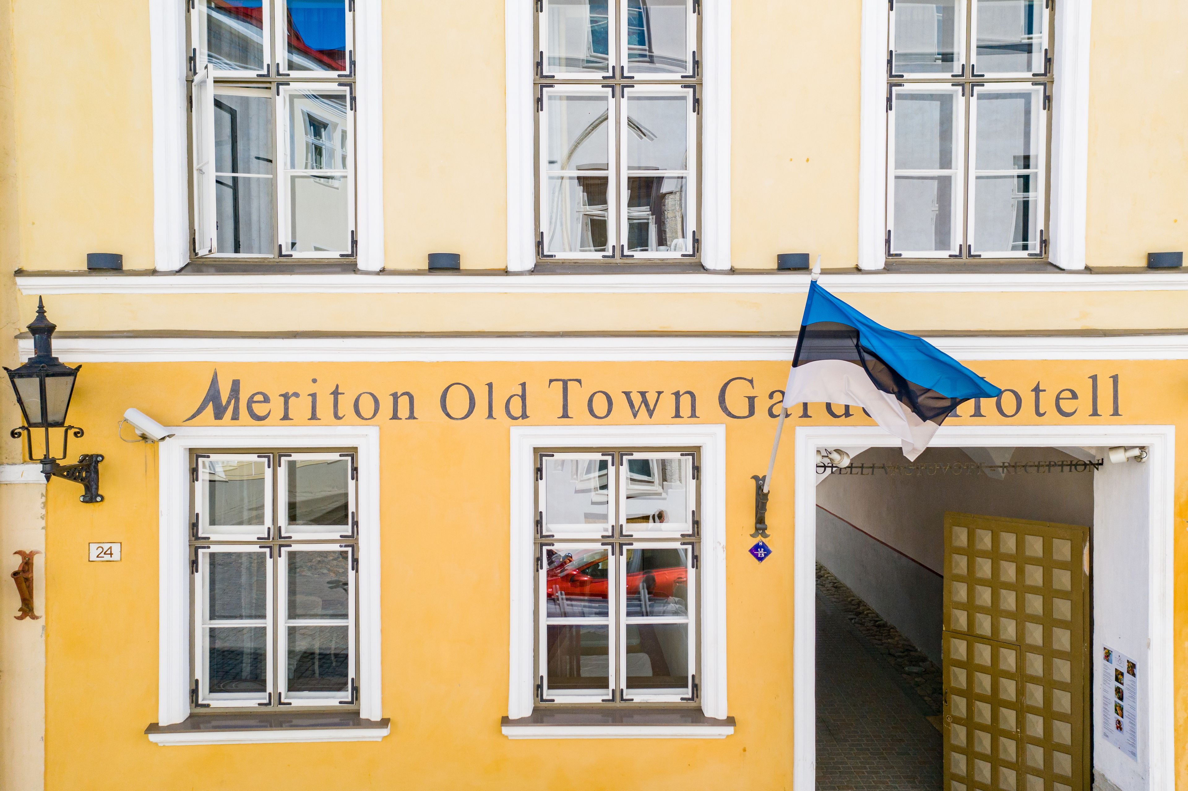 A building with a sign reading "Meriton Old Town Garden Hotel."