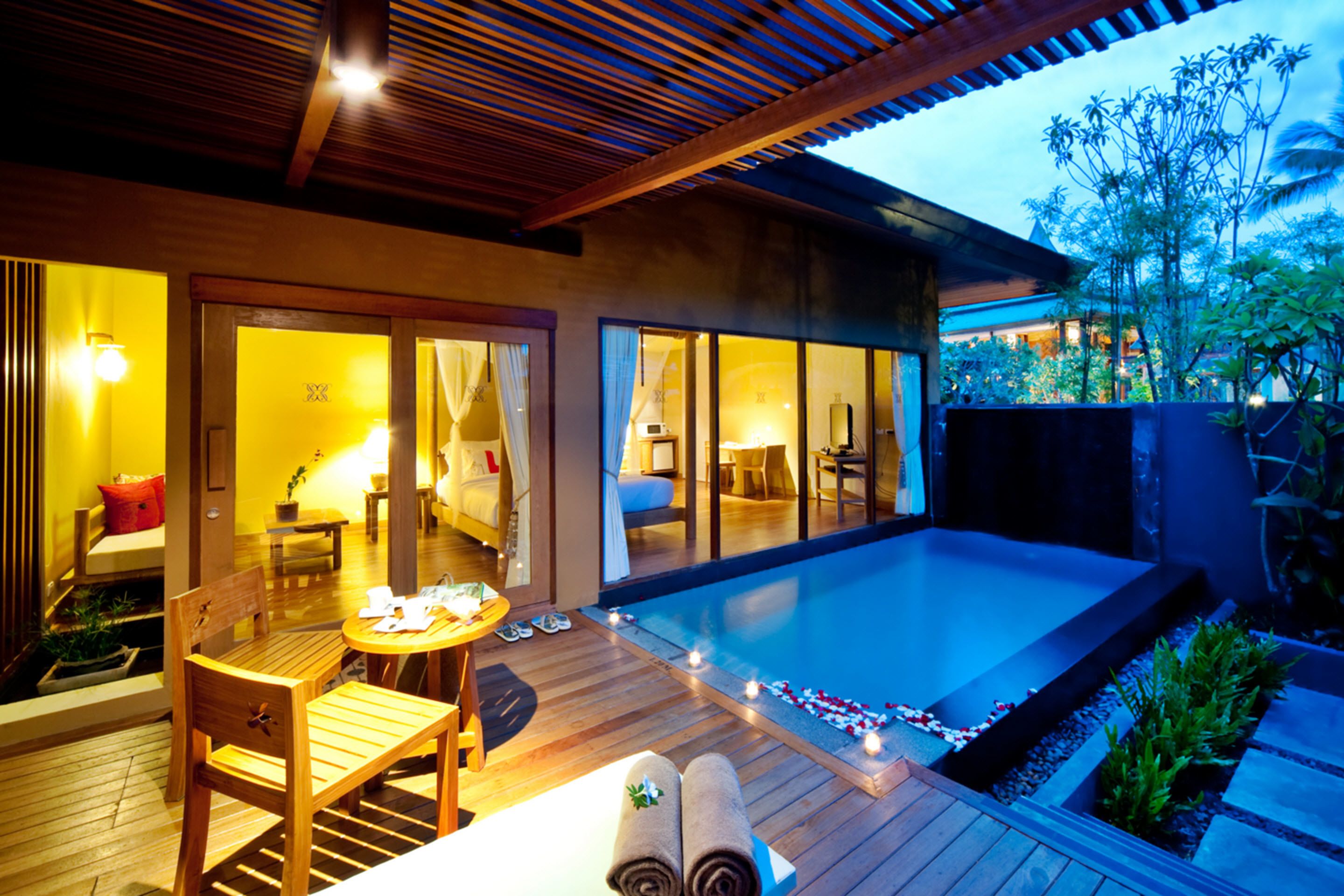 Un hôtel moderne doté d’une piscine, d’une terrasse en bois et d’espaces de détente intérieurs et extérieurs.
