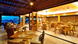 Un restaurant avec des meubles en bois et une vue sur la plage.