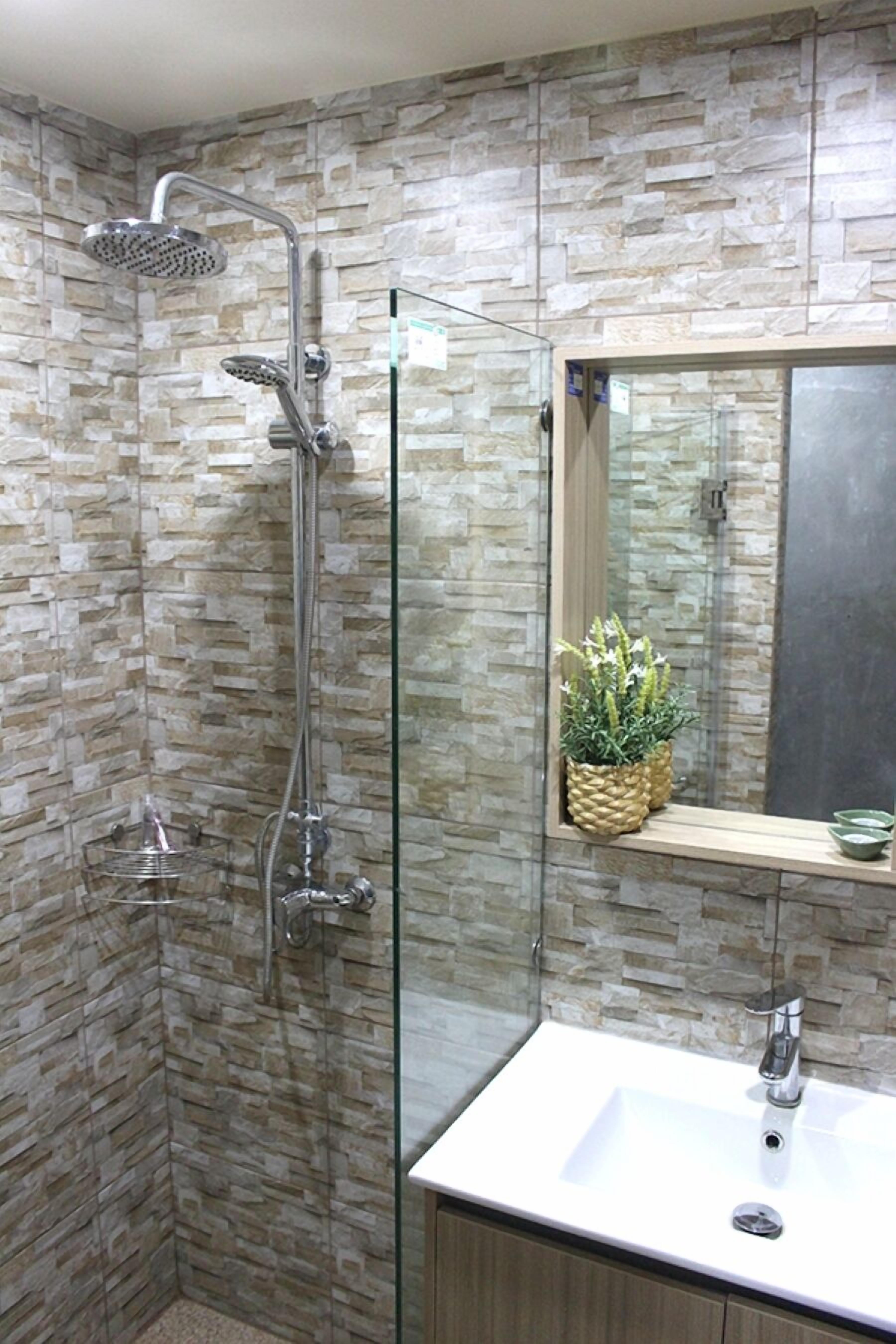 Ein Badezimmer mit Dusche, Waschbecken und Spiegel.