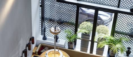 Un intérieur moderne avec de nombreuses tables et chaises, de grandes suspensions en forme de globe et des plantes en pot.