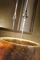 A hot tub with a metallic interior and a reflective surface above it.