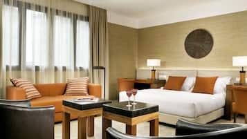 Una habitación de hotel con una cama, un sofá, una mesa de centro y un escritorio.