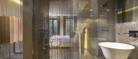 Une salle de bain moderne avec un grand lavabo blanc, une douche en verre et une chaise en bois.