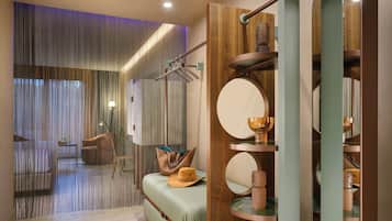 A modern interior with a sofa, a mirror, and a wooden shelf with decorative items.