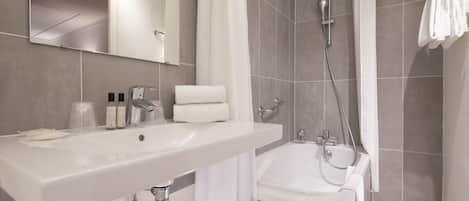 A modern bathroom with a large sink, a bathtub, and a shower.