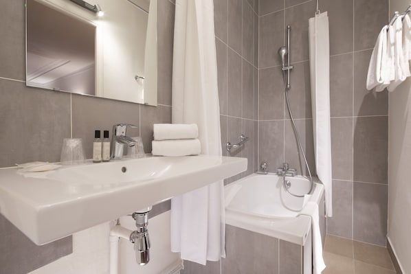 Un baño moderno con un lavamanos grande, una bañera y una ducha.