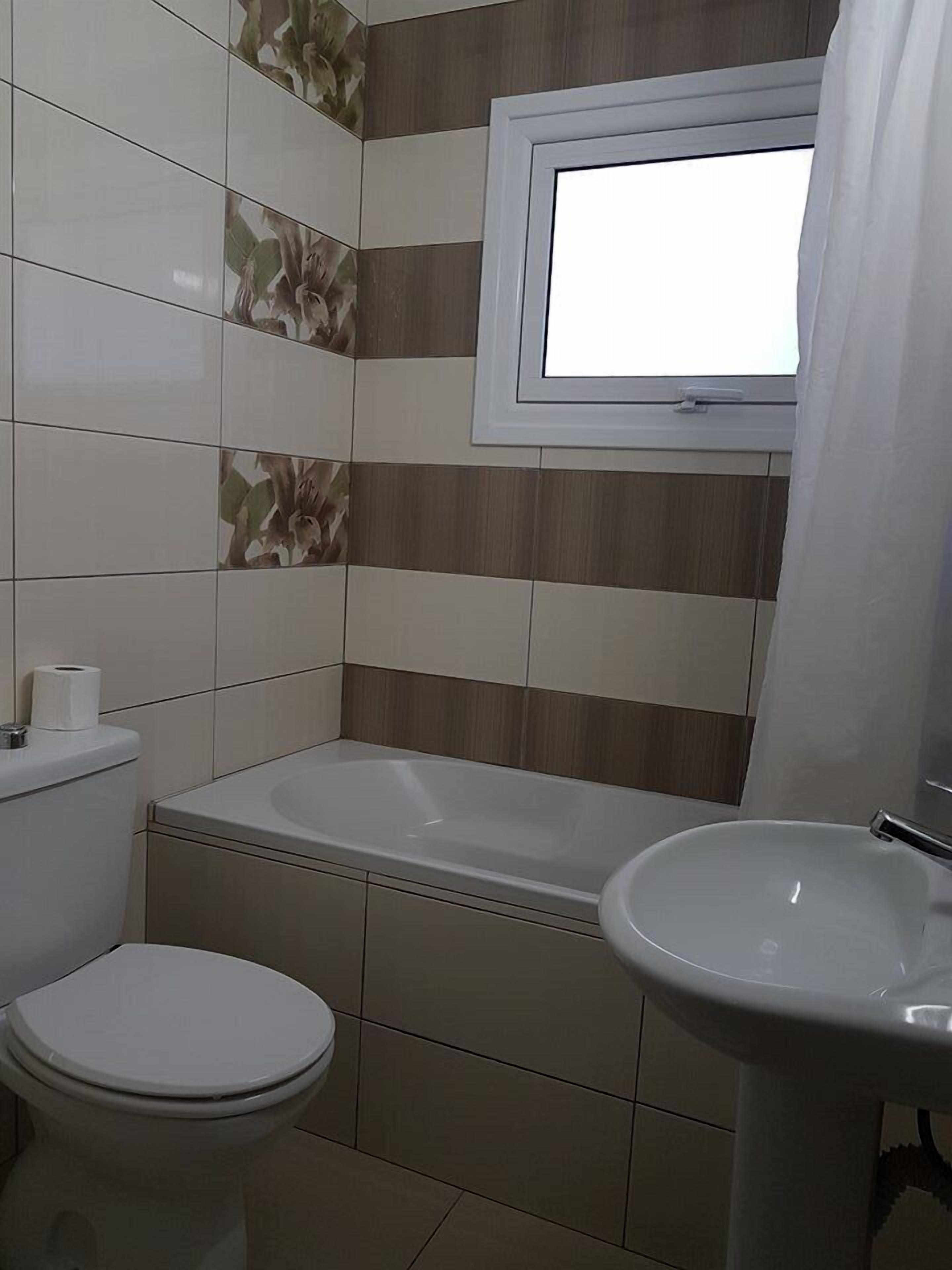Un baño con inodoro, bañera y lavamanos.