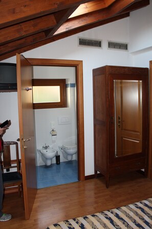 Enter a room with a door leading to a bathroom featuring a toilet and sink.