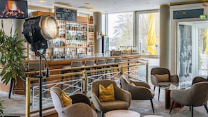 Un espace bar avec un assortiment de bouteilles d’alcool, des sièges confortables et une grande fenêtre offrant une belle vue.