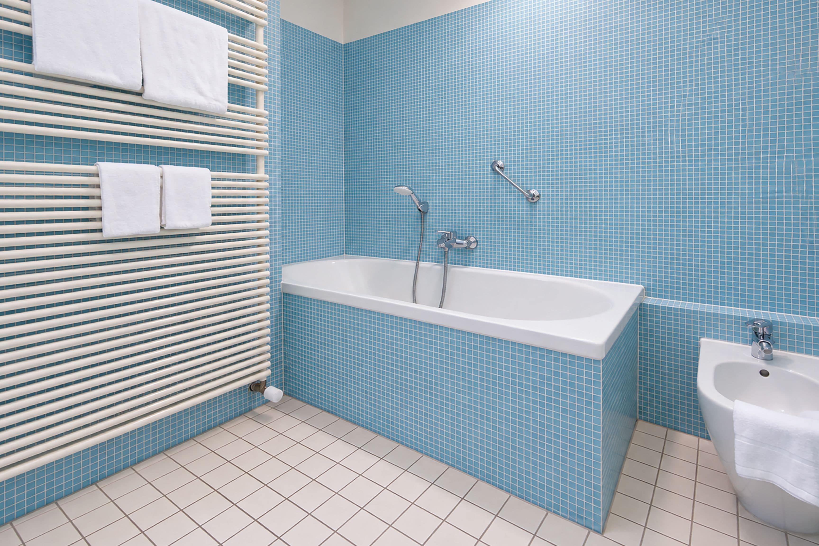 A bathroom with a bathtub, a shower, and a sink.
