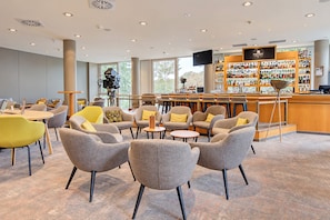 A modern bar area with seating and a variety of liquor bottles. - Seminaris Sunday Hotel Potsdam Babelsberg (Potsdam)