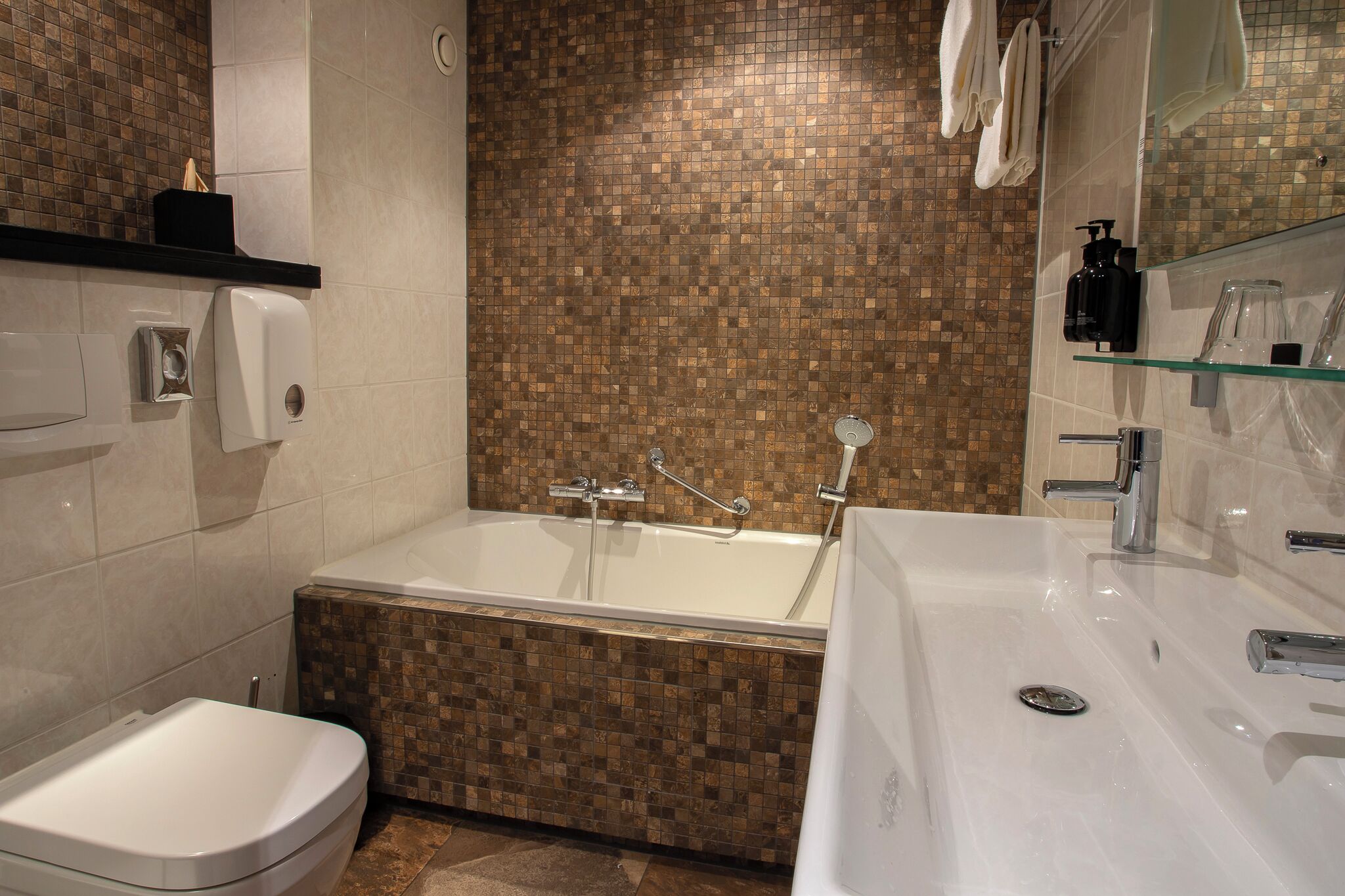 Un bagno moderno con una vasca, un water e un lavandino.