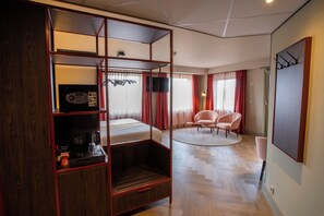 A hotel room with a bunk bed, a desk with a computer, a chair, a round rug, and a TV. - Greenside (De Koog)