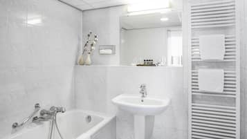 Un baño moderno con una bañera, un lavabo y un perchero para toallas.