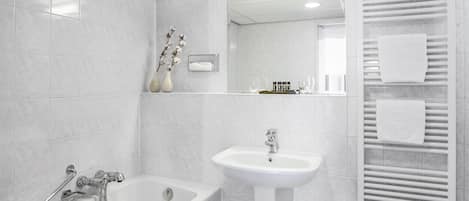 Ein modernes Badezimmer mit Badewanne, Waschbecken und Handtuchhalter.