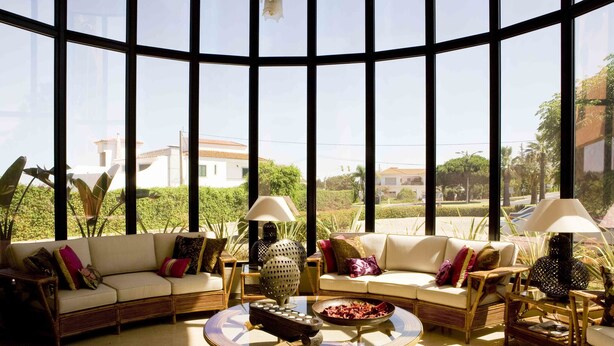 A spacious living area with a large window, two sofas, a coffee table, and two lamps. - Parque Das Laranjeiras (Loulé)
