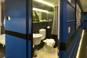 Ein modernes Badezimmer mit Toilette, Waschbecken und Duschvorhang.