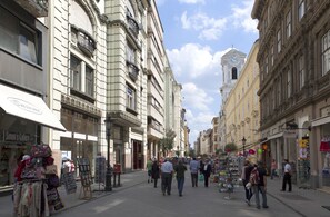Eine Straße mit Geschäften und einem Glockenturm.