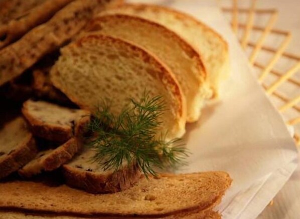 Des tranches de pain grillé sur une assiette blanche, garnies d’une branche d’aneth.