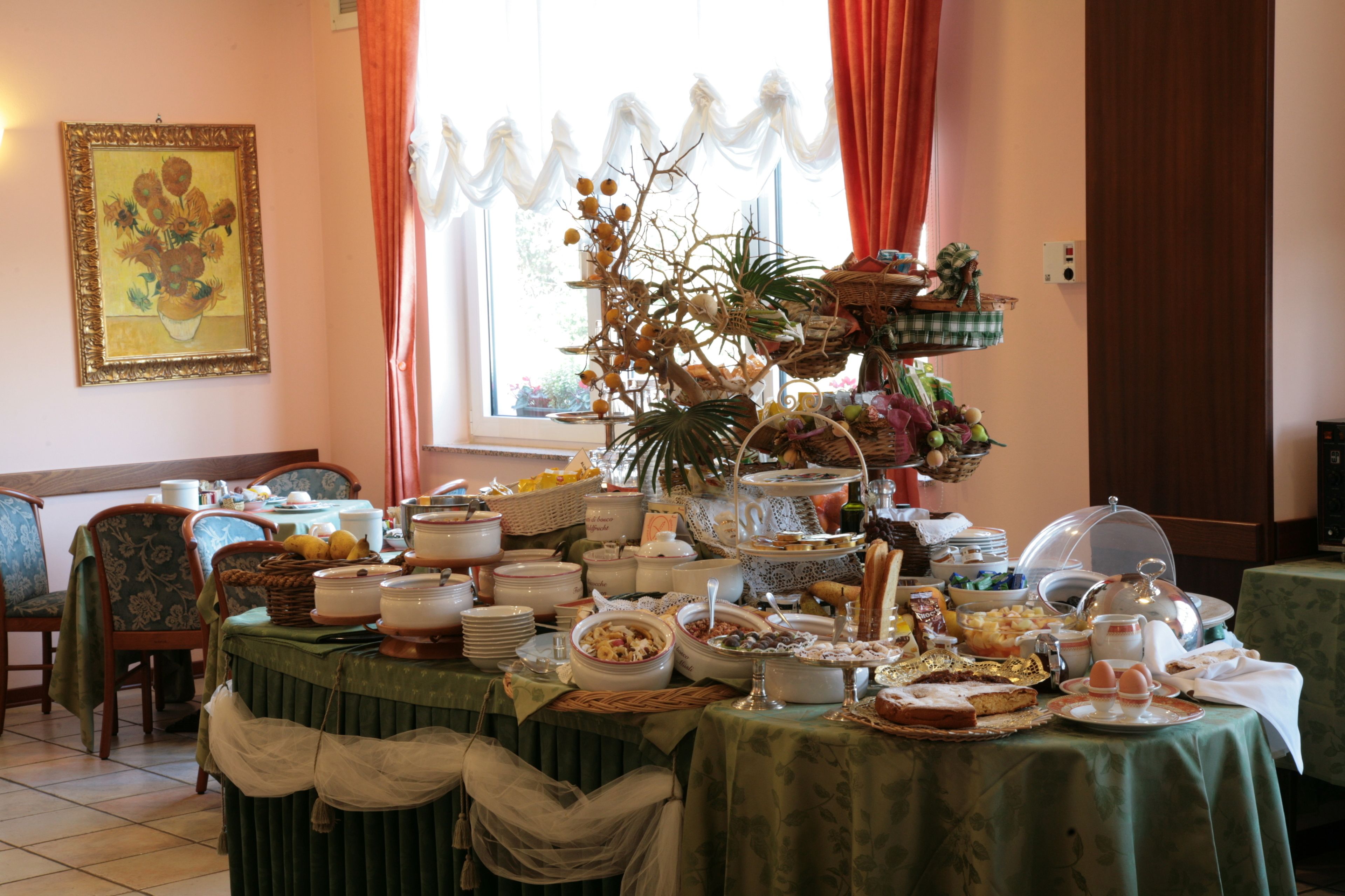 A dining area with a buffet table set up with various dishes and a decorative plant centerpiece.