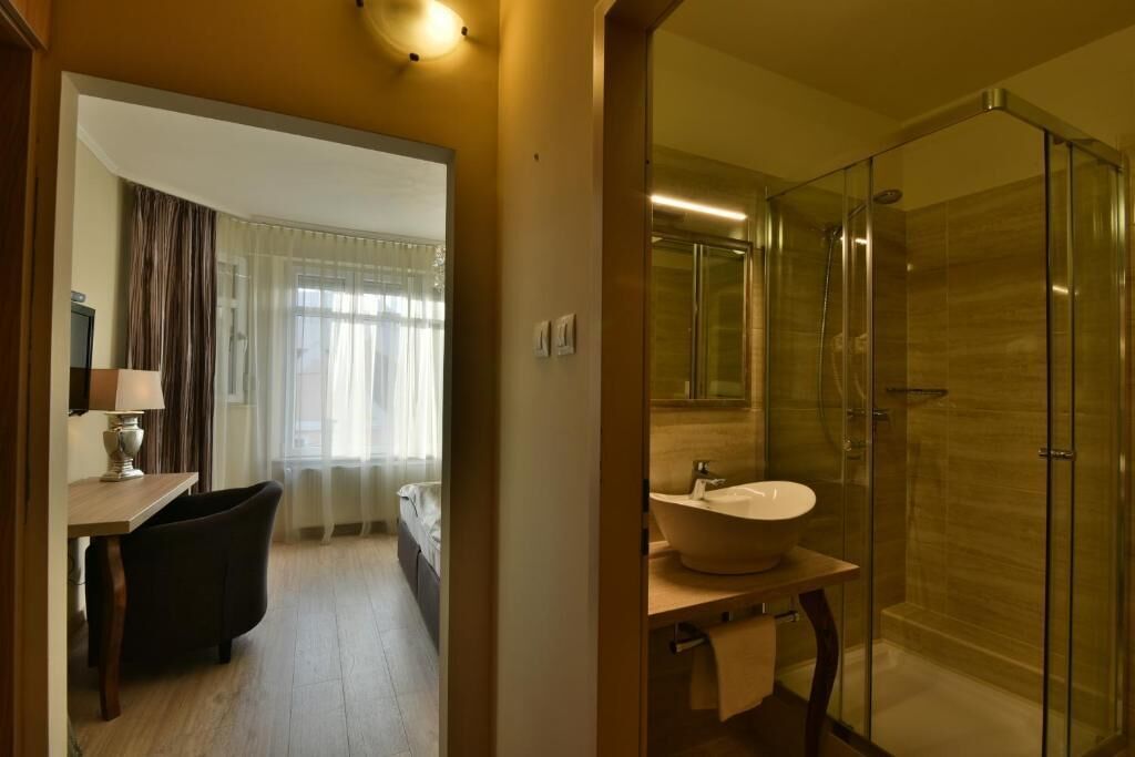 A modern bathroom with a glass-enclosed shower, a freestanding sink, and a visible toilet.