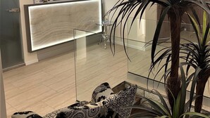 A modern reception area with a glass counter, a chandelier, and a large plant. - Hunyadi (Gyor)
