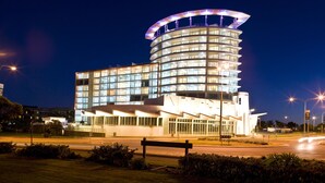 A modern hotel with a curved, multi-story structure and a prominent circular top. - Kirra Surf Apartments (Coolangatta)