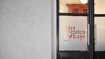 A door with a sign that reads "Het Schouten huys".