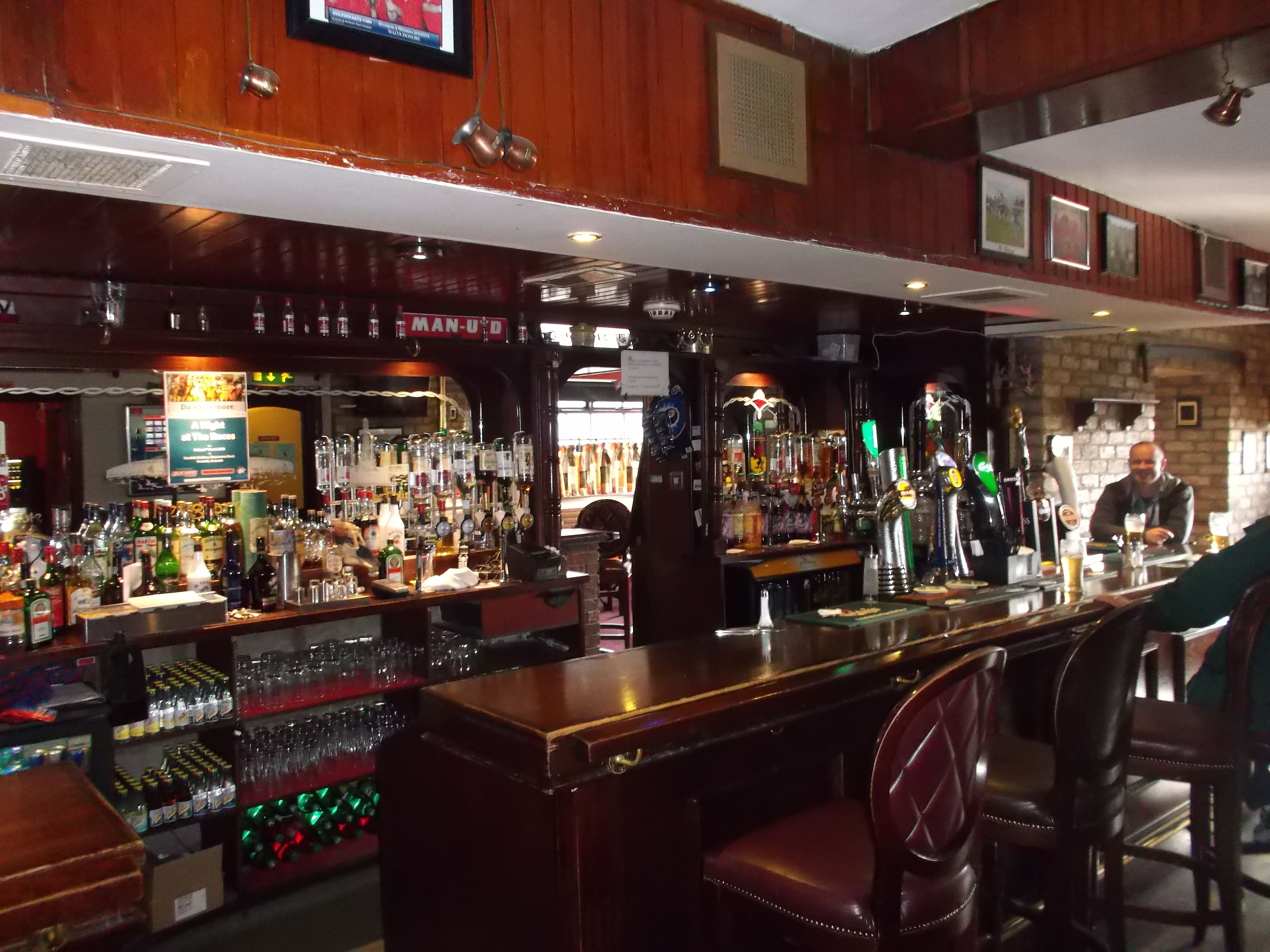 A bar with a variety of liquor bottles, glasses, and a counter.
