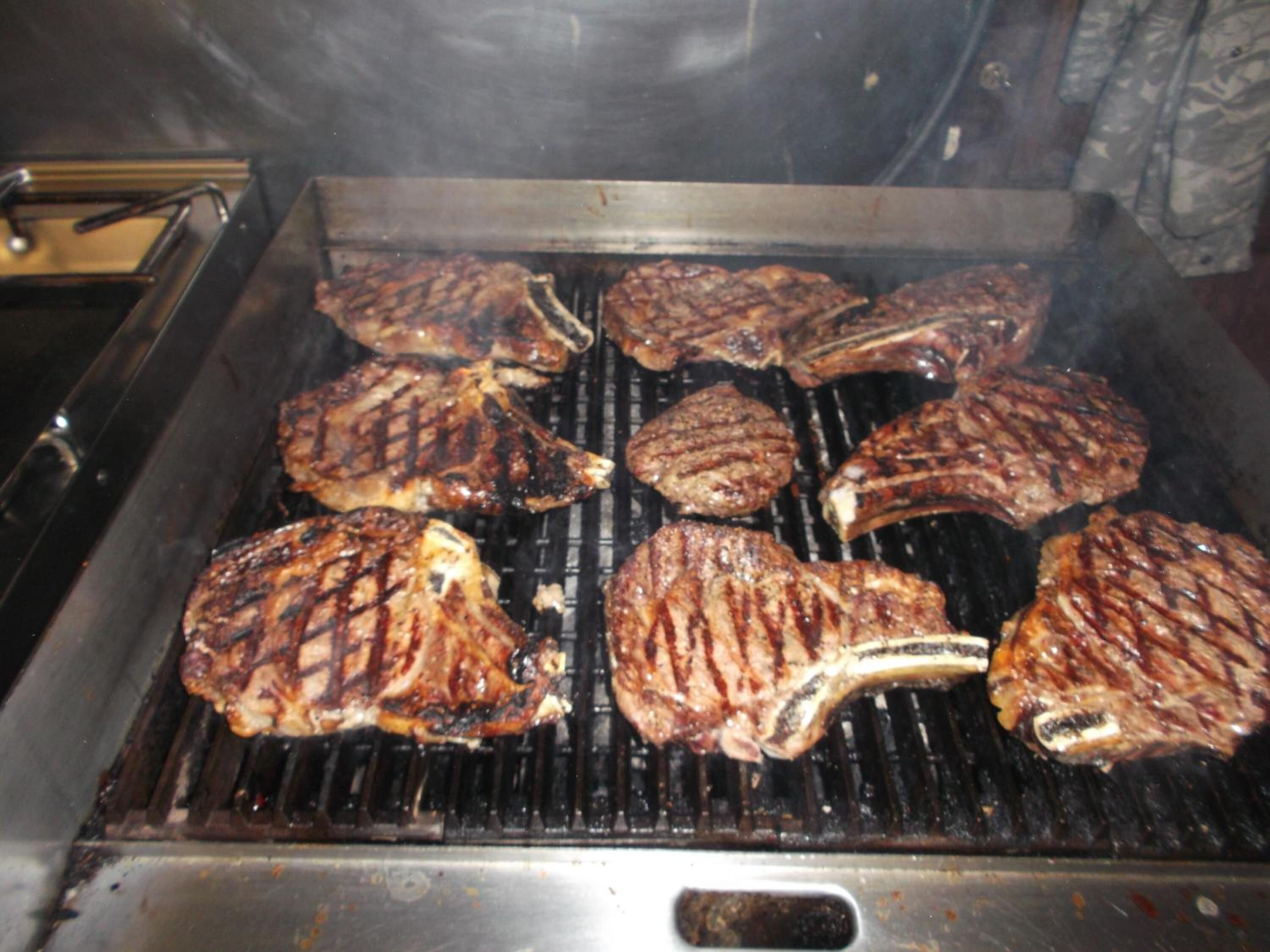 Un gril sur lequel plusieurs steaks sont en train de cuire.