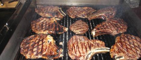 Ein Grill mit mehreren Steaks, die darauf gebraten werden.