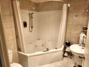 A modern bathroom with a freestanding bathtub, a showerhead, and a toilet. - BKs Premier Motel Palmerston North (Palmerston North)