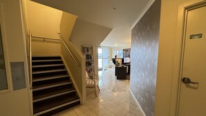 A hotel hallway with a staircase, a reception desk, and a 'Fire Control Room' sign.