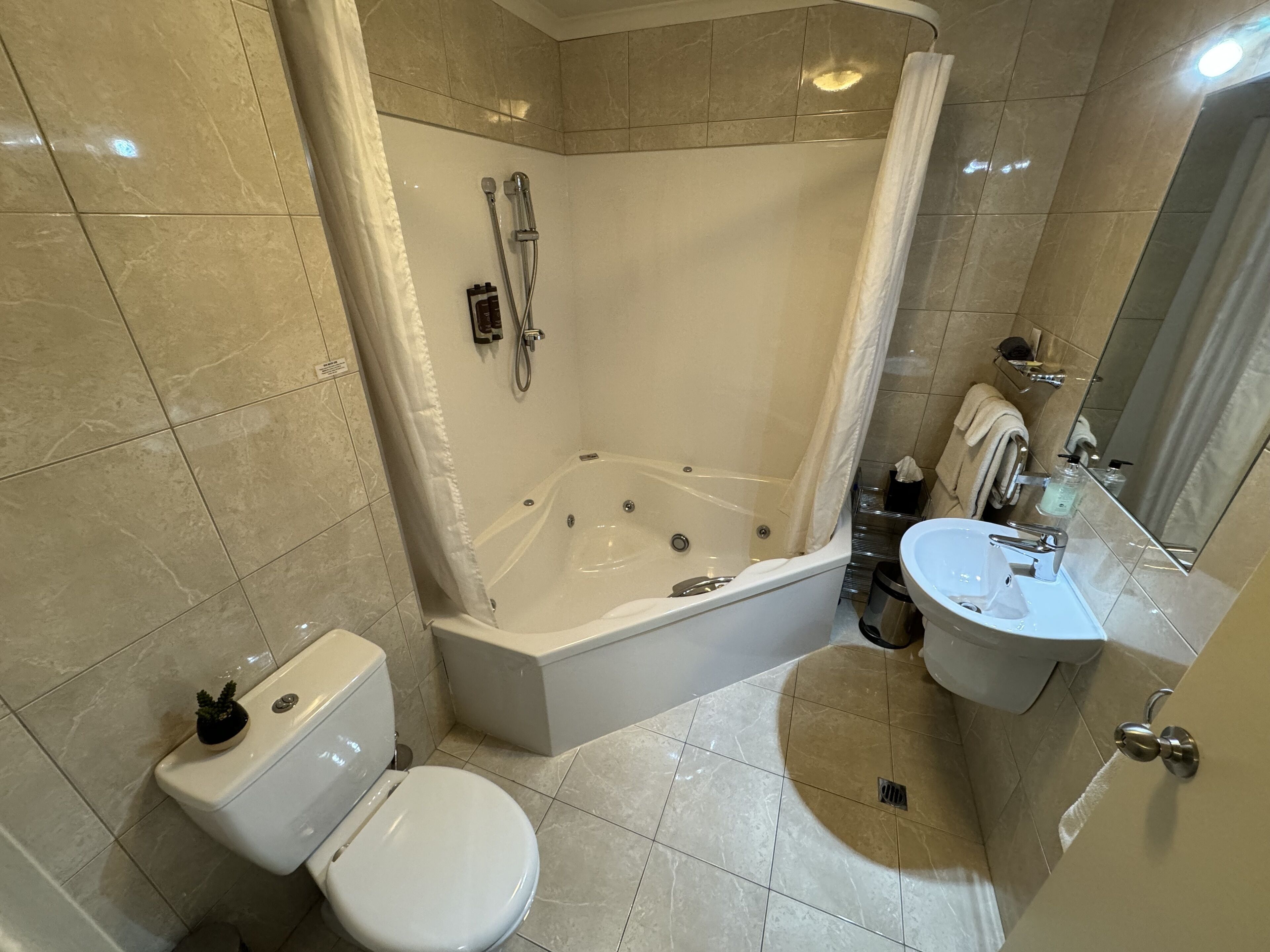 A modern bathroom with a bathtub, toilet, and sink.
