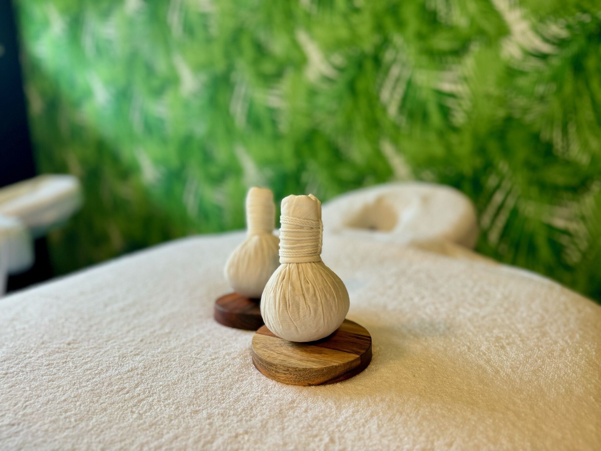 A massage table with two wooden massage stones and a white towel.