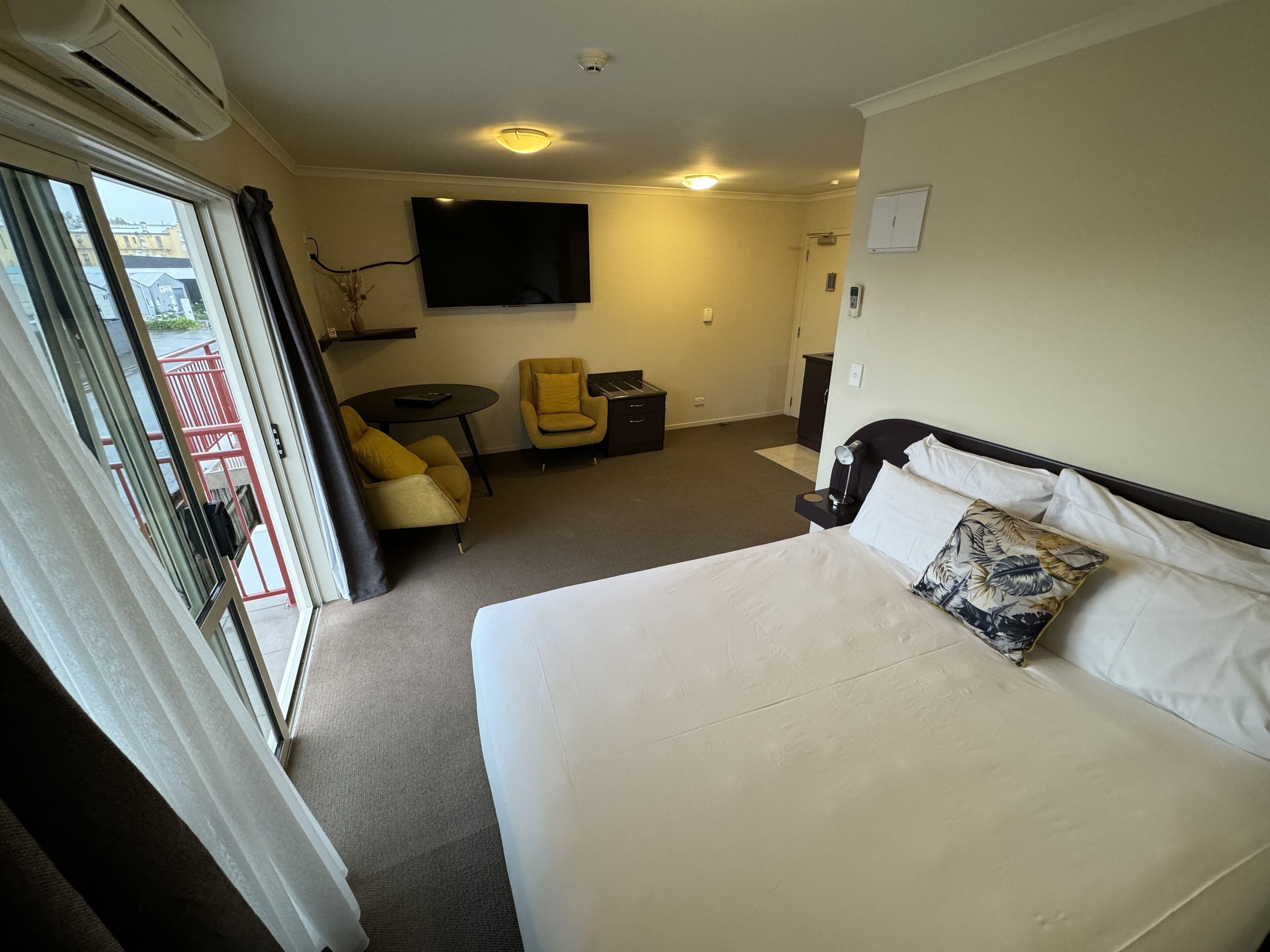 Een hotelkamer met een bed, een bureau, een stoel en een televisie.