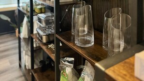 A shelf with packaged goods and empty glasses.
