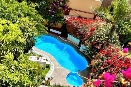 Una piscina al aire libre, sillones reclinables de piscina