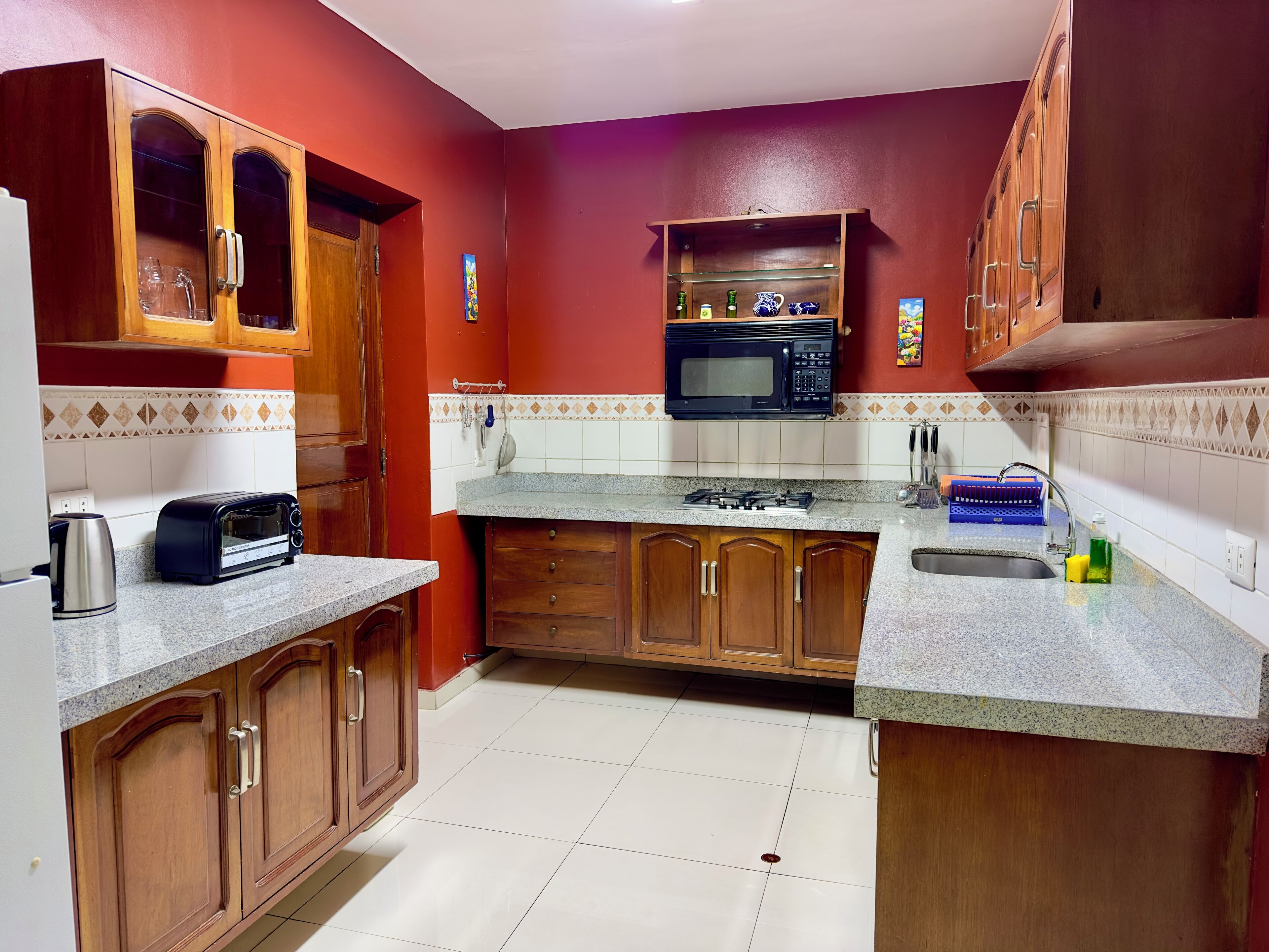 A kitchen with wooden cabinets, a microwave, a gas stove, and a sink.