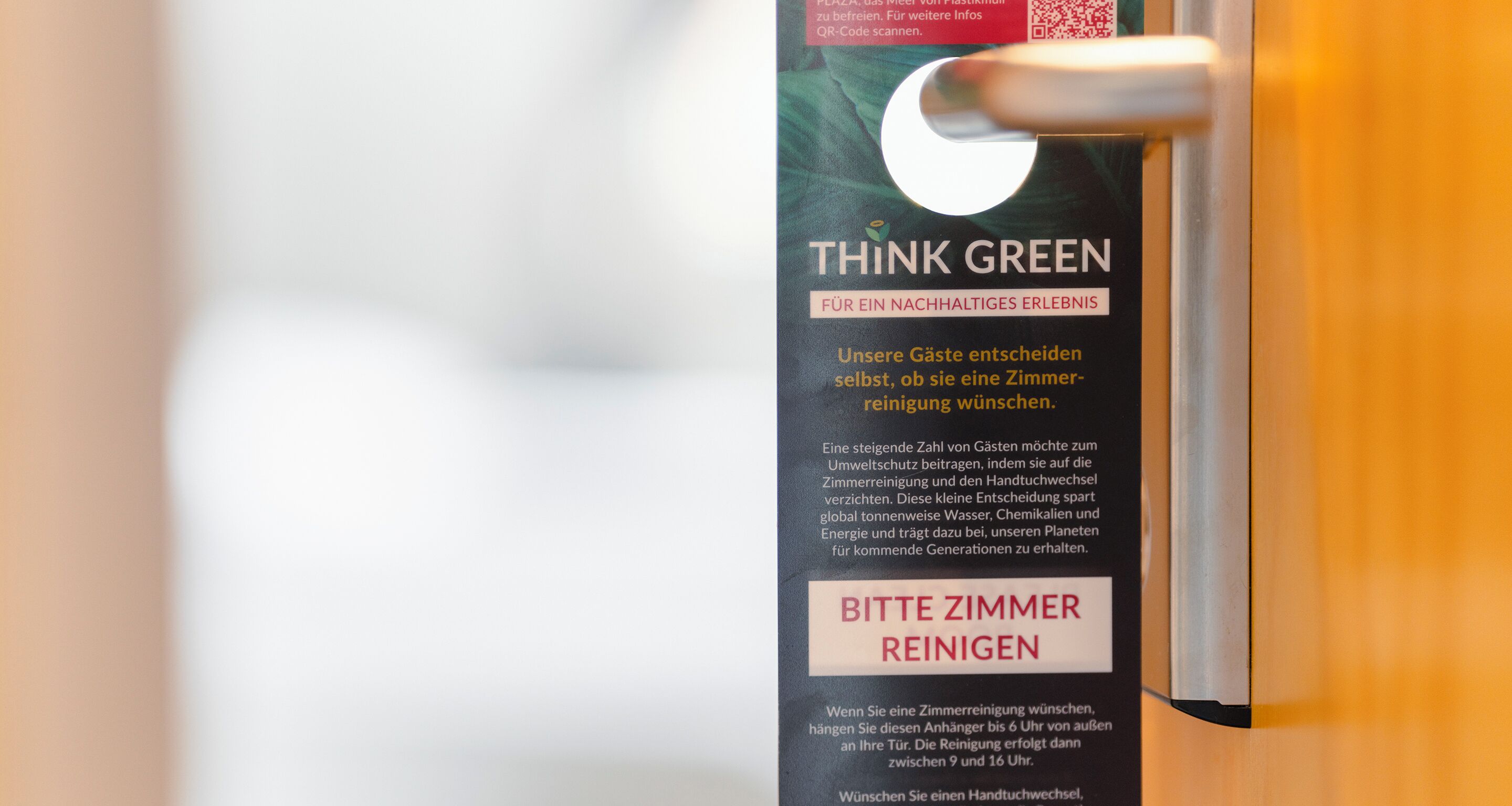 Eine Tür mit einem Schild, auf dem steht: "THINK GREEN FOR A SUSTAINABLE EXPERIENCE" und "BITTE REINIGEN".