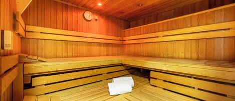 Una sauna con bancos de madera y un reloj en la pared.