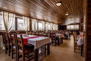 A restaurant with wooden ceiling and tables set for dining. - Elegant Lodge Hotel (Bansko)