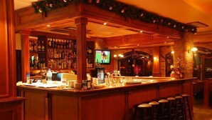 A bar area with wooden decor, a television, and a well-stocked liquor shelf. - Elegant Lodge Hotel (Bansko)