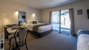 Una habitación de hotel con cama, escritorio, silla y televisor.
