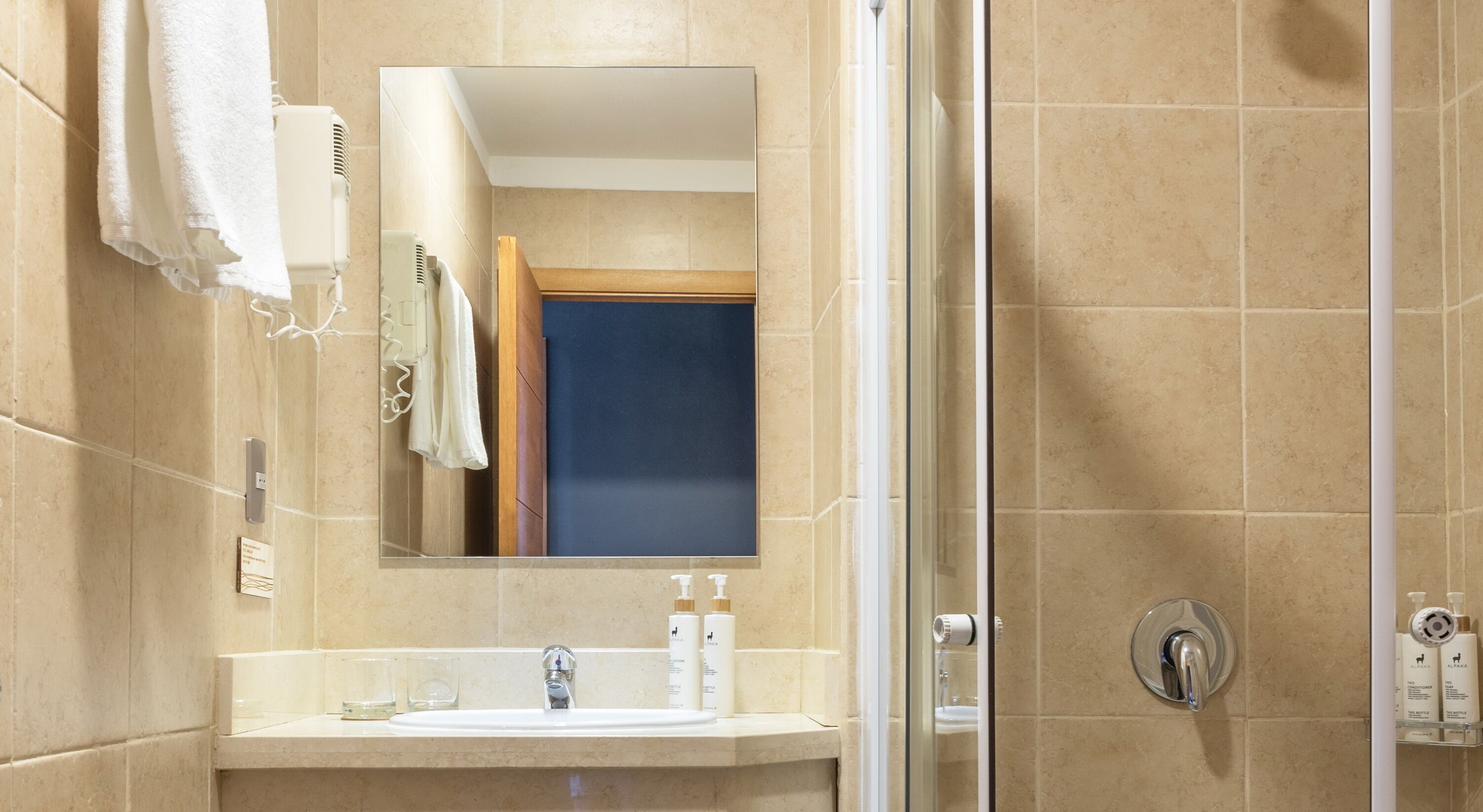 Une salle de bain avec un miroir, un lavabo et des articles de toilette.